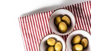 green round fruits on stainless steel bowl, olives