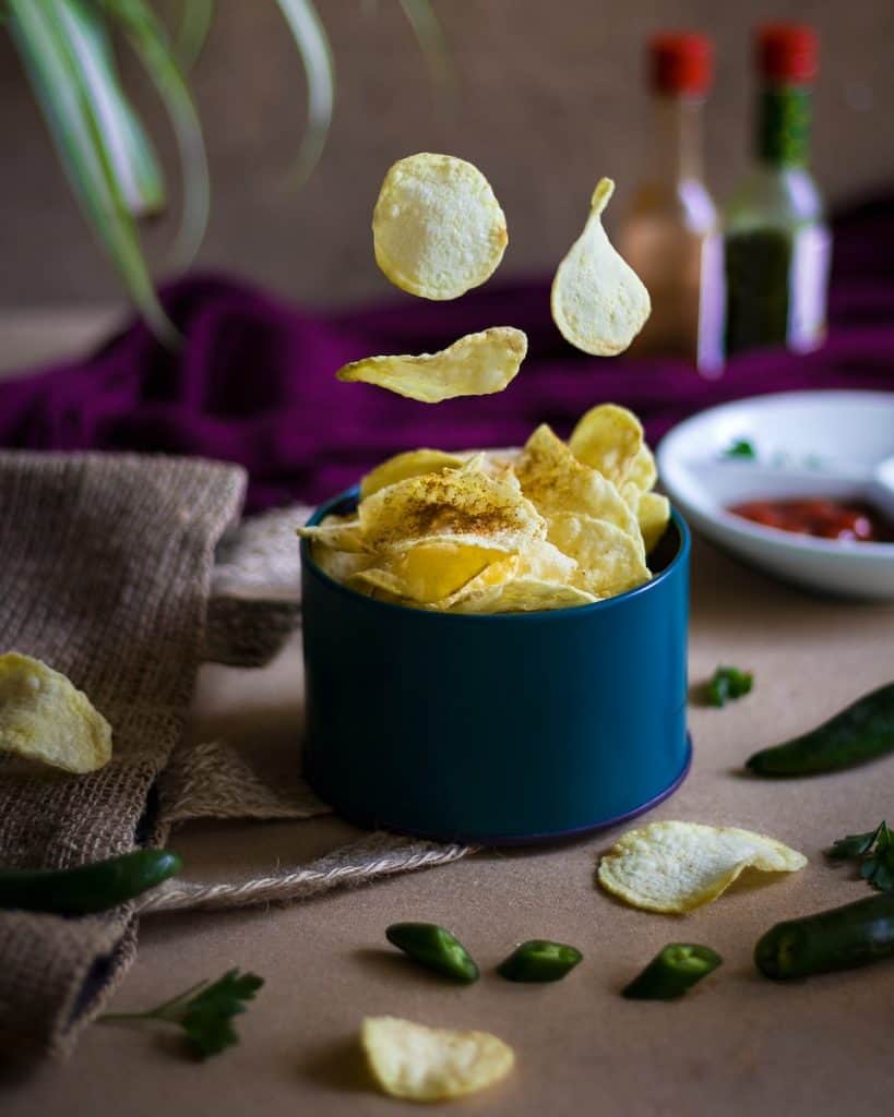 potato chips, blue ceramic mug on green table cloth
